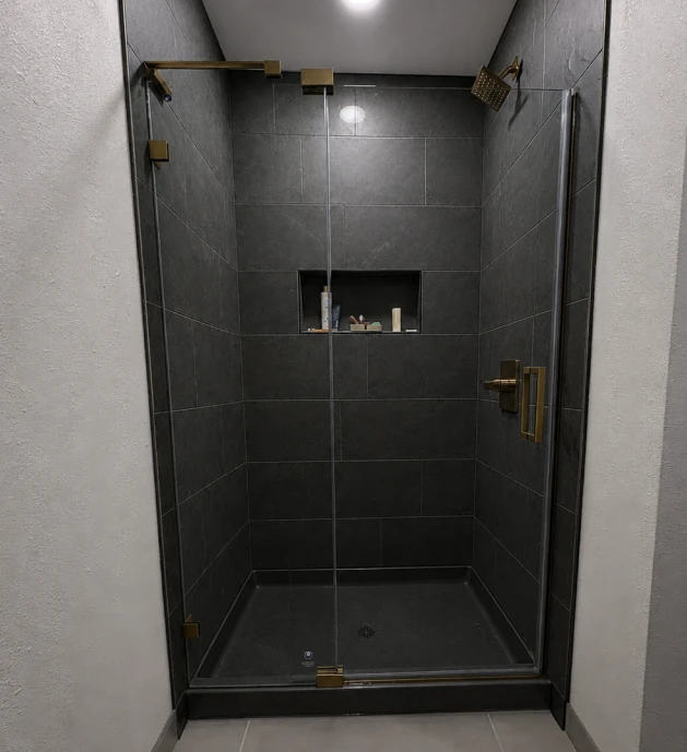 Jimmy's finished Comfystyle frameless pivot shower door between dark tile walls